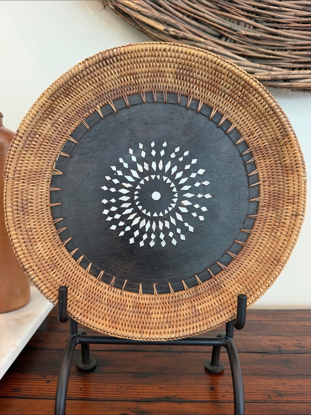 Woven Rattan Decorative Plate Basket with Black Center and Inlaid White Pattern.